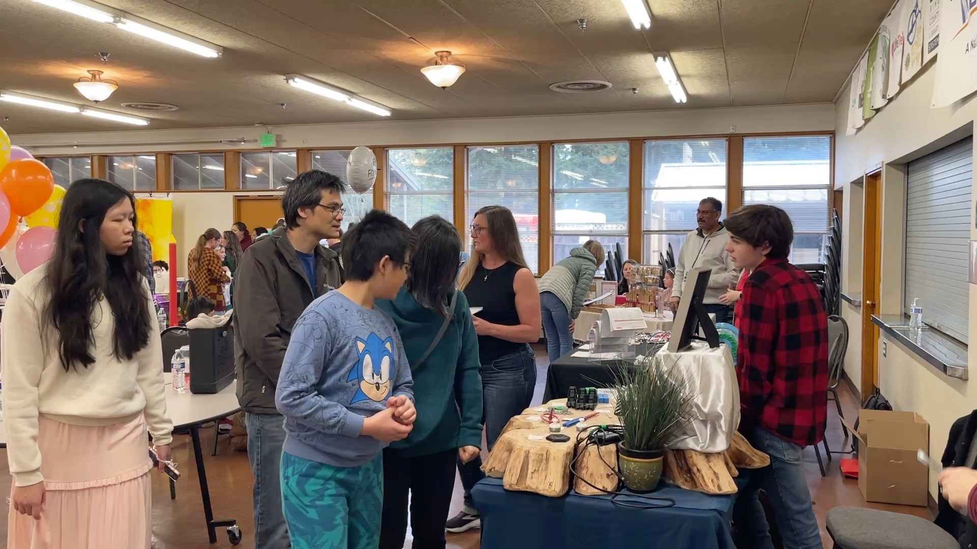 Families browsing kid-run vendor tables at the Maple Valley Children's Business Fair