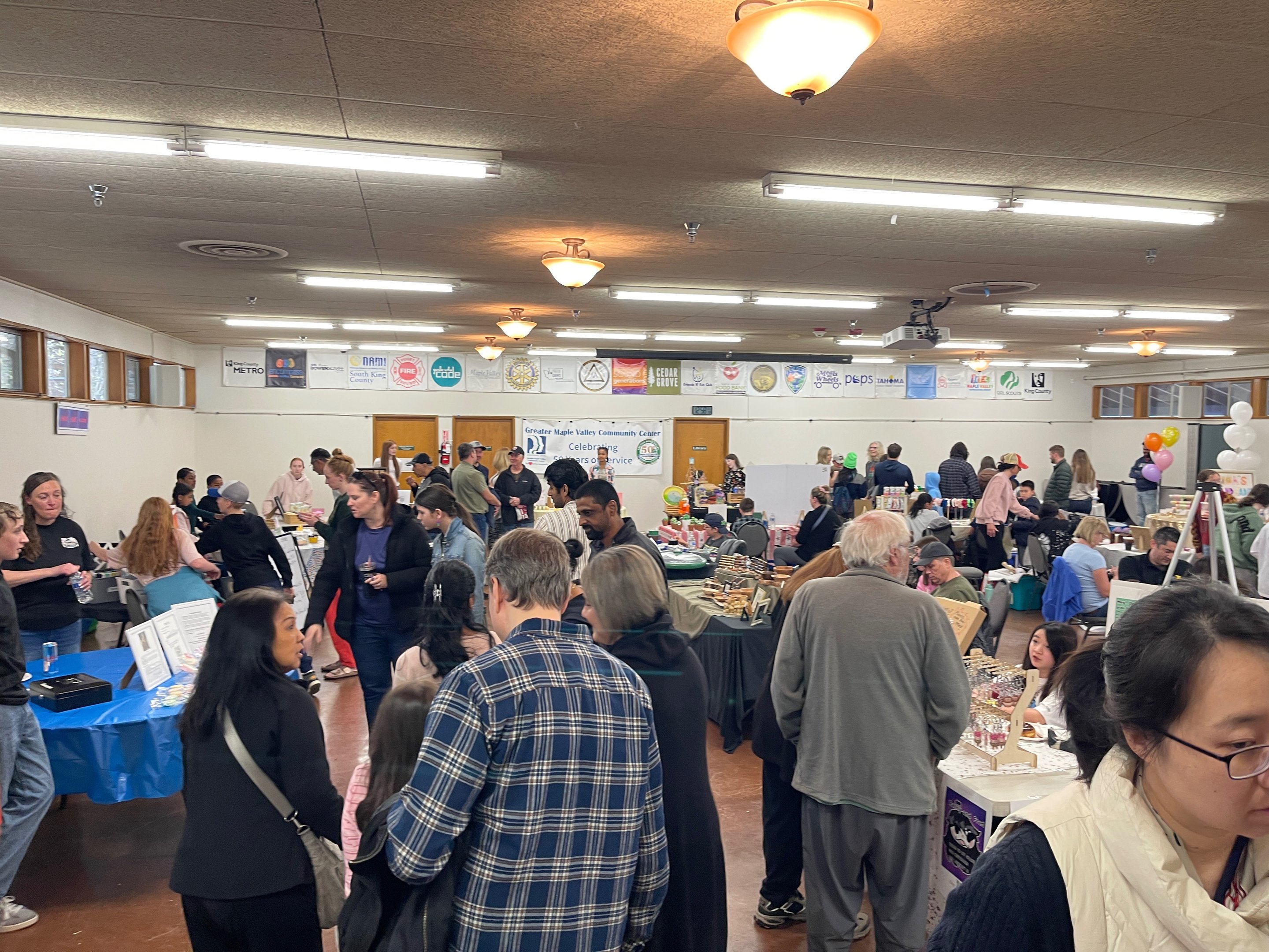 Crowded fair floor at the Greater Maple Valley Community Center during the Maple Valley Children's Business Fair