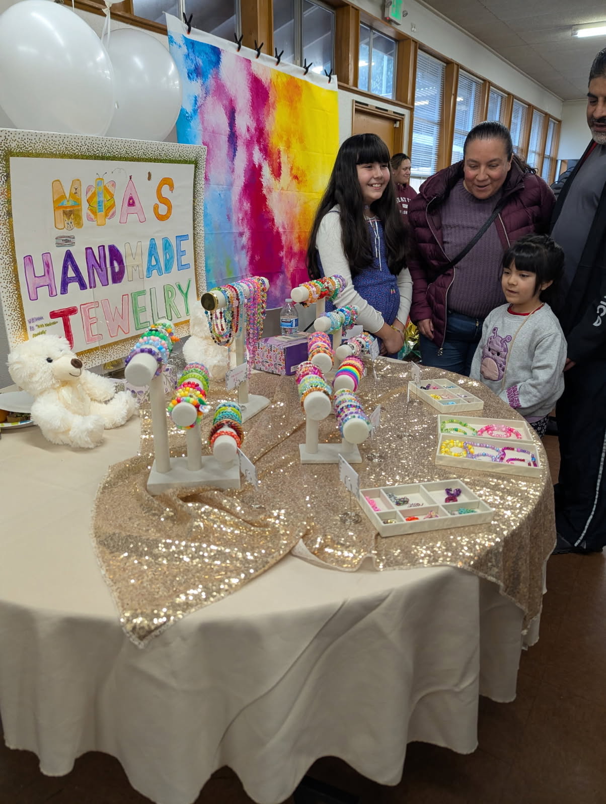 Young entrepreneur's 'Nova's Handmade Jewelry' booth with beaded bracelets and necklaces