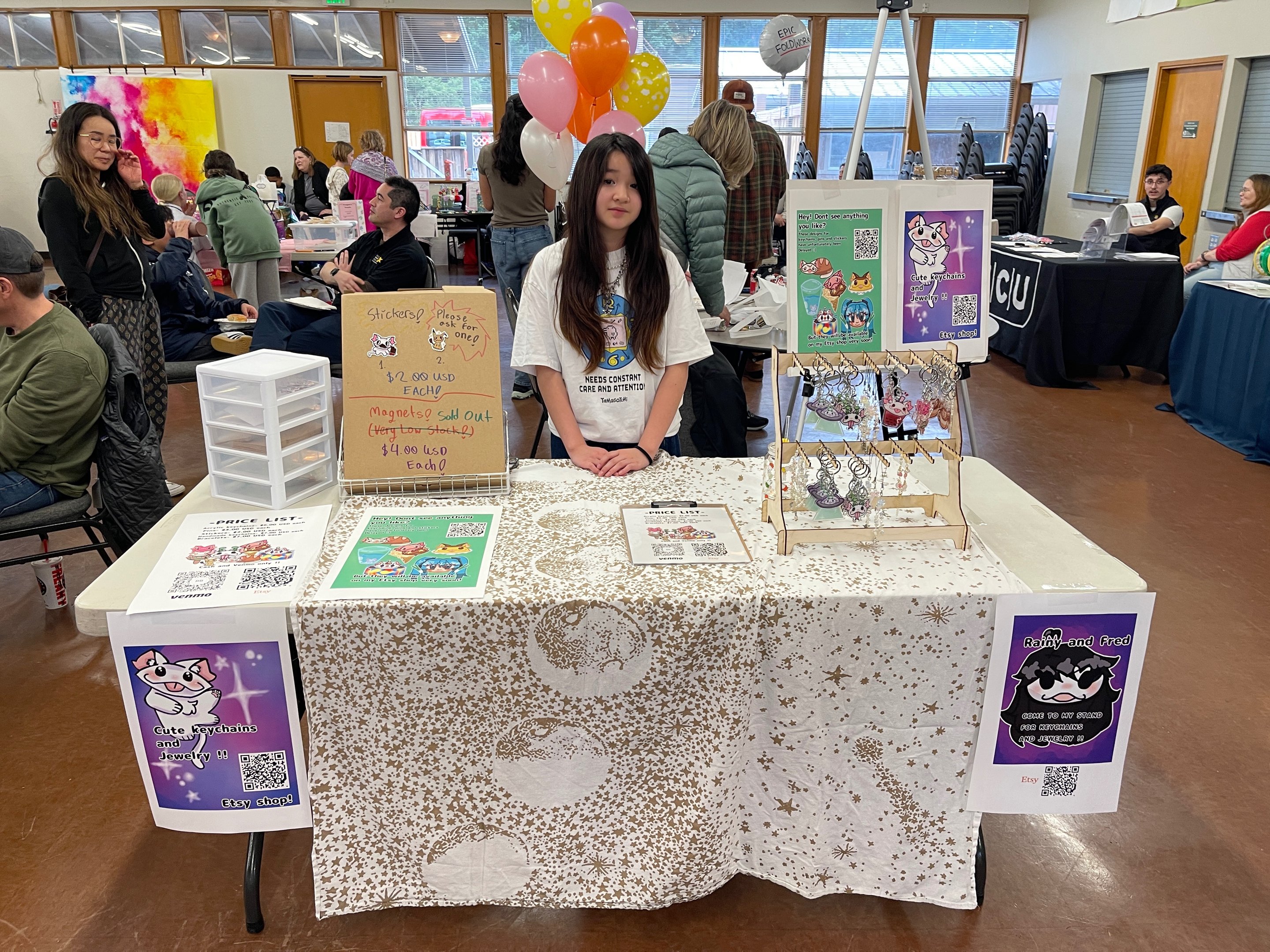 Teen entrepreneur's keychain and jewelry booth with an Etsy shop QR code